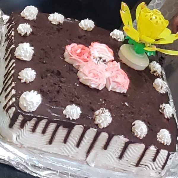 كيكة شوكولاتة كبيرة بتزيين كريمي وردي وأبيض