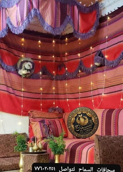 ركن استقبال تراثي وردي وأحمر بإضاءة دافئة